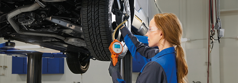 A Subaru technician checking tire pressure. | Subaru of Gallatin in Gallatin TN