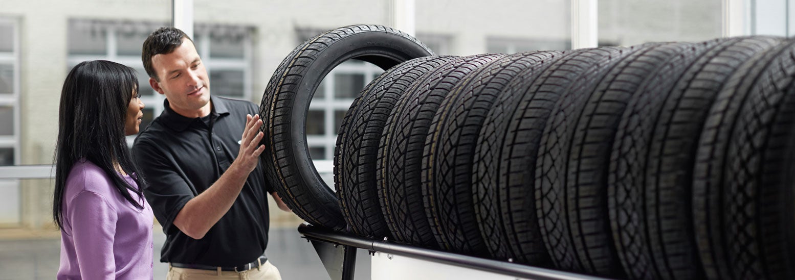 Subaru service representative showing customer a tire. | Subaru of Gallatin in Gallatin TN